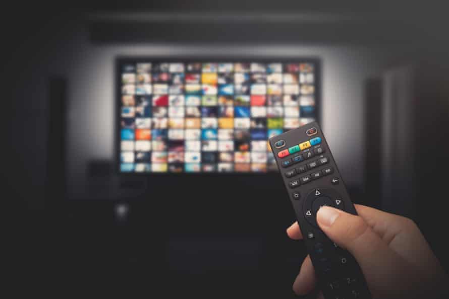 A television with dozens of streaming services displayed, and a remote in the foreground of the photograph