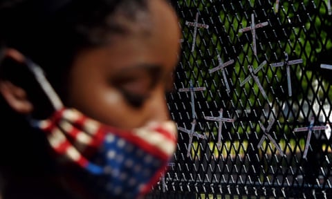 A demonstrator next to a fence bearing names of black people killed by police, Washington DC, June 2020. 