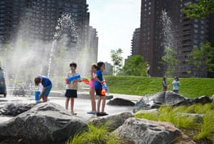 Children playing in water fountain areas of the park with water pistols