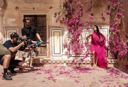 Freida Pinto being photographed for the calendar by hanging pink blossom.