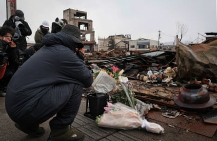 A man prays for victims at the tourist attraction Wajima Asaichi where a large-scale fire broke out in Wajima, Ishikawa prefecture