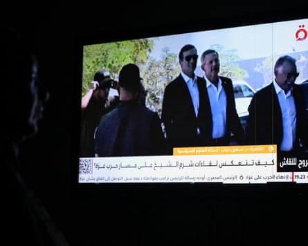 An Egyptian woman watches footage of the US Middle East envoy Steve Witkoff and Trump’s son-in-law Jared Kushner arriving in Sharm el-Sheikh for talks.