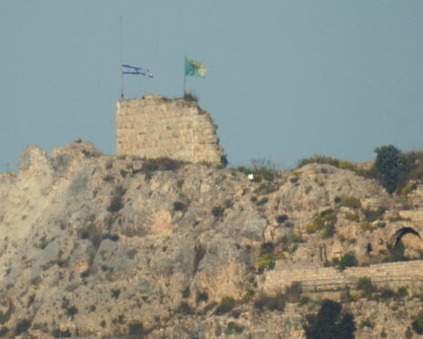 Two flags fly on ancient fort on hilltop