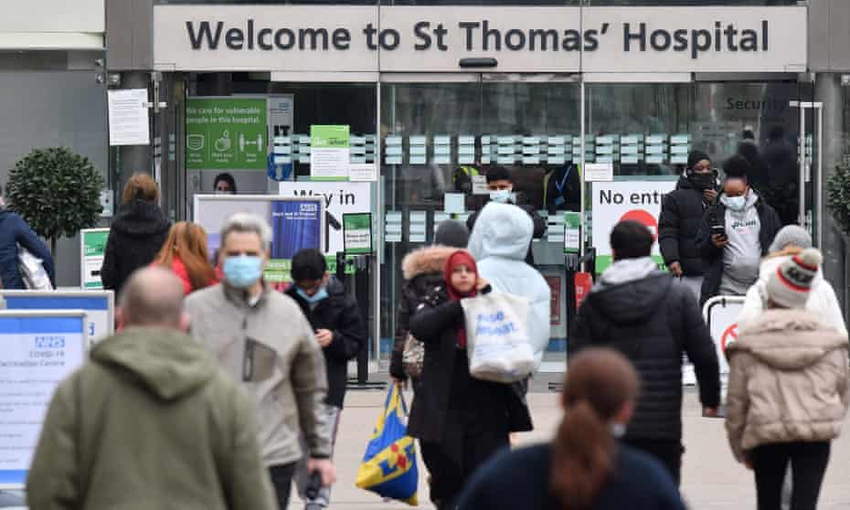 People outside St Thomas' hospital, many in masks