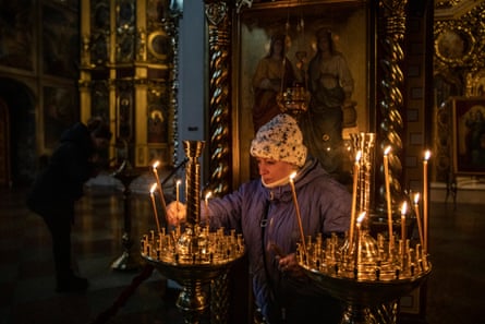 A woman lights a candle at St Michael’s Cathedral in Kyiv