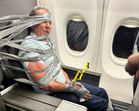 a man is secured to a plane seat with duct tape