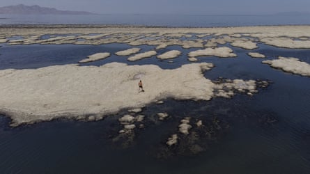 man walks across reef-like structures