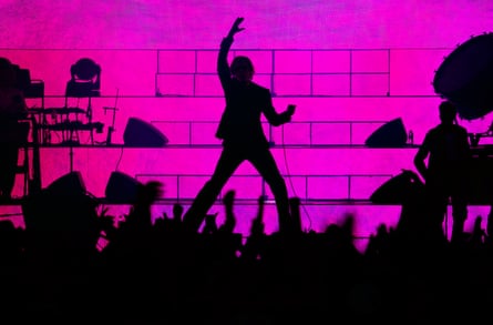 Jarvis Cocker silhouetted onstage against pink light
