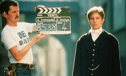 Streisand on the set of Yentl, the 1983 film that took her 15 years to get made. Streisand in costume next to a man with a clapperboard