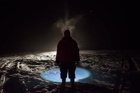A Canadian Ranger, illuminated by a snowmobile and his headlamp during a snowstorm, helps pull a net using under-ice fishing techniques for Arctic char during a patrol on King William Island, Nunavut. Canadian Rangers are a volunteer, community-based military unit. In the Arctic they are mostly Inuit.