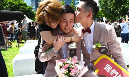 An emotional Shane Lin (C) is comforted by his new husband Marc Yuan (R) and a friend during a wedding ceremony in Shinyi district in Taipei.