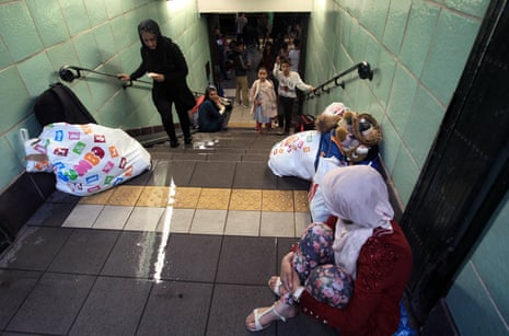 Women and children on a staircase in an underground station