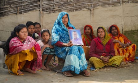 Laduwati Yadav holds a photo of her husband, Gangaram Mandal, who died suddenly hours after the end of his shift as a labourer in Qatar.