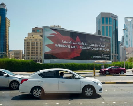 Cars pass a billboard in Manama that reads 'Bahrain is safe ... because you are its people'
