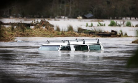 A vehicle is submerged in the Kumeu river as heavy rain causes extensive flooding and destruction in Auckland, New Zealand.