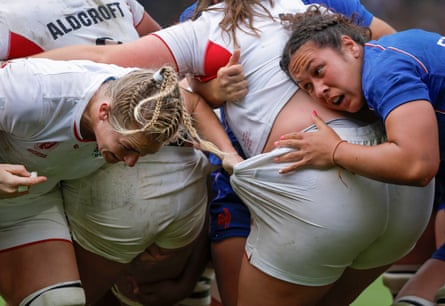 The England No 8 Alex Matthews grabs hold of the shorts of teammate Maud Muir as they push forward on an attacking rolling maul while France’s Teani Feleu pushes the other way.