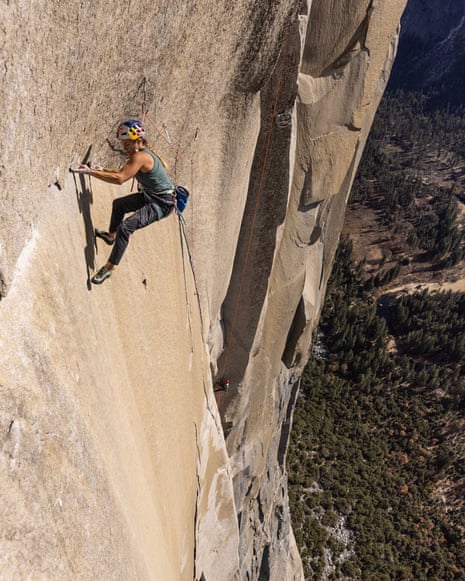 Woman on sheer rock face many thousands of feet above a valley