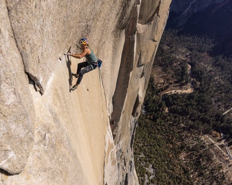 Woman on sheer rock face many thousands of feet above a valley