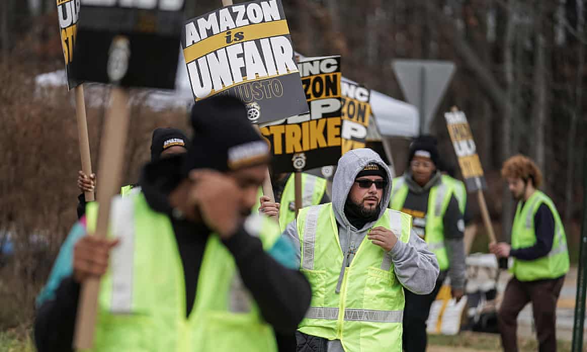 People hold signs and march during a strike by Teamsters union members