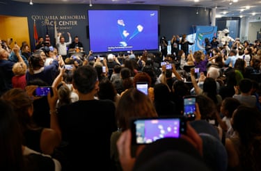 İnsanlar, 10 Nisan 2026'da Kaliforniya'nın Downey kentindeki Columbia Anıt Uzay Merkezi'nde düzenlenen bir izleme partisinde, görevin başarılı bir şekilde suya inişinin canlı yayınını izliyor.