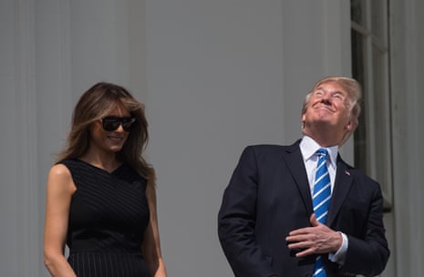 Trump looks skyward before donning protective eyewear to view the eclipse