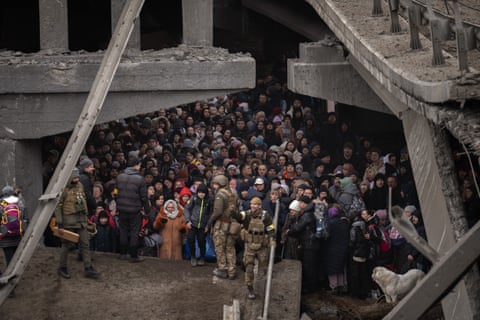 Ukrainians crowd under a destroyed bridge as they try to flee crossing the Irpin river in the outskirts of Kyiv, Ukraine, 5 March