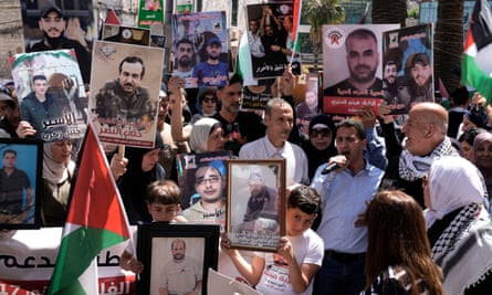 Palestinians hold photographs of detainees in Israel during a rally marking the annual prisoners’ day in the West Bank city of Nablus on 17 April 2024.
