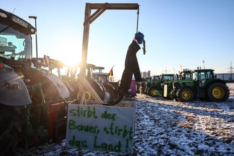 A tractor carries a hanging mannequin and a banner reading “If the farmer dies, the country dies!”  » in a field on a cold morning on the second day of a nationwide farmers' strike near Bernau bei Berlin.