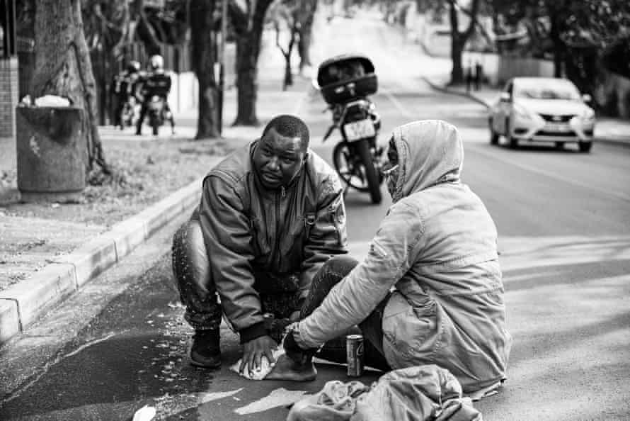 Ghost riders: the invisible lives of Johannesburg food couriers – photo essay | South Africa 15 Ugandan driver Bashir, puts ice on a colleagues injured foot after a crash.