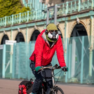Un ciclista con una máscara protectora recorre Madeira Drive en Brighton.