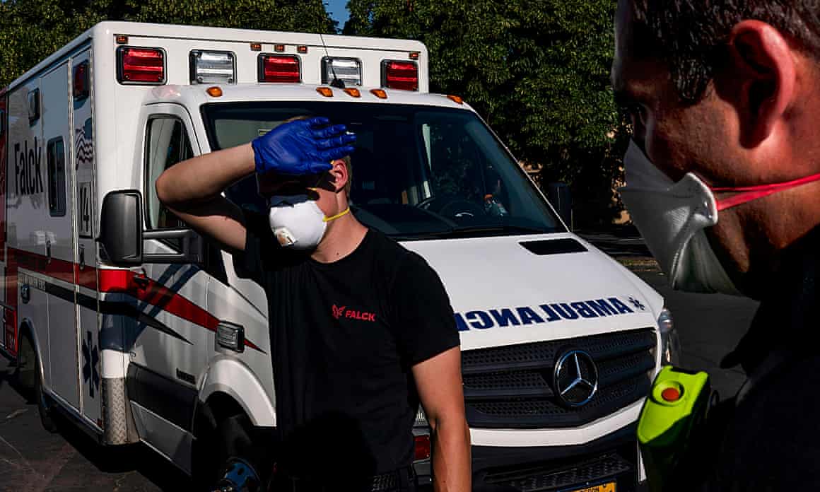 A paramedic shields his eyes while treating a man experiencing heat exposure during a heatwave in Salem, Oregon, on 26 June 2021.