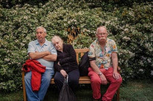 three people who look tired sitting on a bench