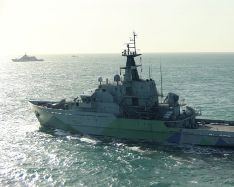 The Russian frigate Admiral Grigorovich sails at sea, monitored by a distant Royal Navy ship