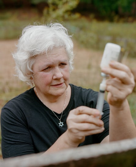 An older woman prepares a vaccine.