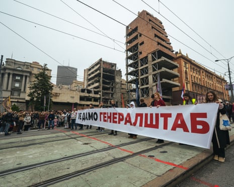 Belgrade protesters hold a banner opposing demolition in front of the bombed General Staff building