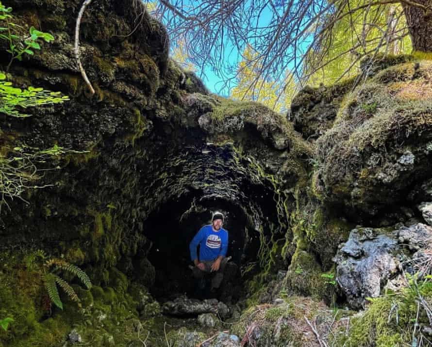 view of a cave's exterior with a man in the middle