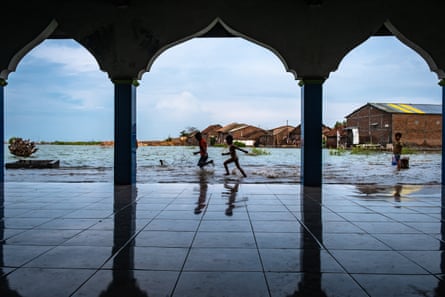 Playing in the flooded yard in front of a mosque.