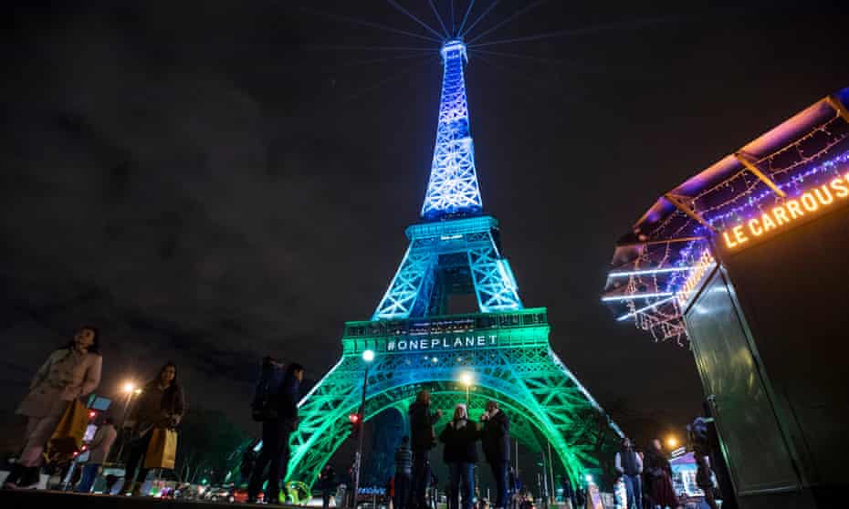 The Eiffel Tower is illuminated by the One Planet Summit colours.