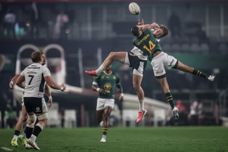 Jaco Williams jumps for the ball with Wales' Ellis Mee