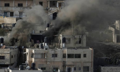 Smoke rises from houses during a bombing raid