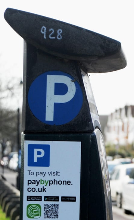 A parking meter with a sign about how to pay by phone on it