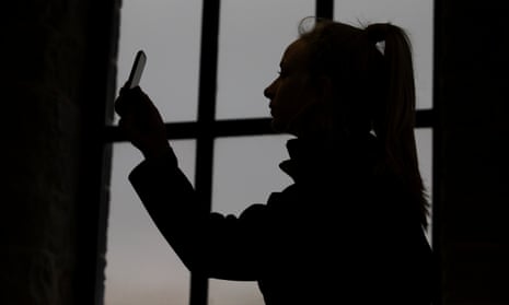 A teenager holding a mobile phone after being taught about the pitfalls of ‘sexting’