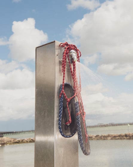 Rope lace ups on a stainless steel post with sea in background