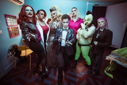 Performers dressed as Doctor Who characters, some in drag, pose backstage
