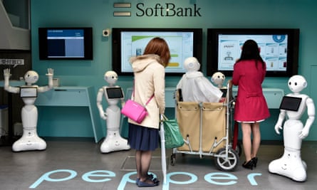 Young women visit a newly opened robot-staffed store where robots welcome customers looking to buy a mobile phone.