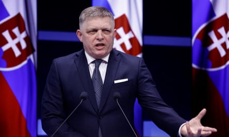 Slovakia's prime Minister Robert Fico delivers a speech against a backdrop of Slovak flags