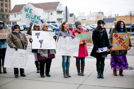 Victim advocates stand outdoors holding signs reading âÂÂWe Believe Youâ and âÂÂThank YouâÂÂ