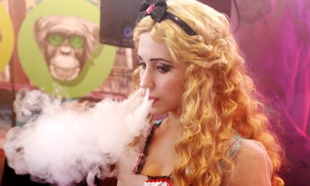 A young woman smokes an electronic cigarette