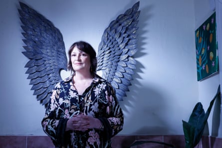 Nardini stands in a room with angel wings on the wall behind her that appear to be attached to her
