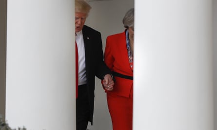 Donald Trump and Theresa May holding hands outside the White House.